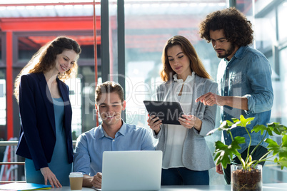 Businesspeople having discussion over laptop and digital tablet