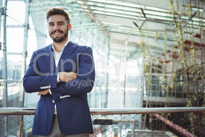 Businessman standing with arms crossed at railway station