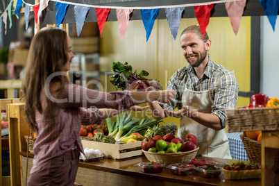 Woman buying beetroot from vendor at the counter