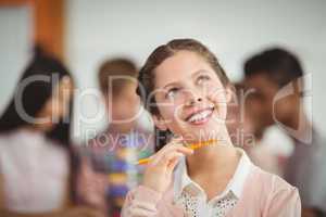 Smiling schoolgirl looking up in classroom