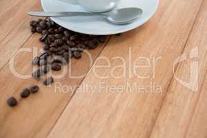 Roasted coffee beans with saucer and spoon