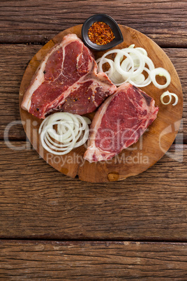 Blade chop, onions and spices on wooden round tray