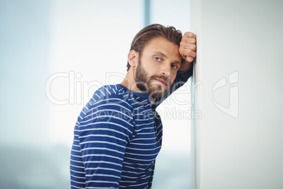 Portrait of sad executive leaning on wall