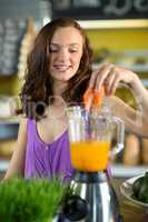 Smiling shop assistant preparing papaya juice