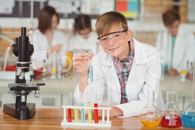 Portrait of schoolboy doing a chemical experiment in laboratory Portrait of schoolboy doing a chemical experiment in laboratory