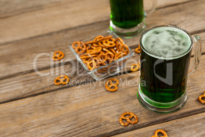 St Patricks Day two mugs of green beer with pretzel