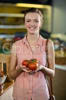 Woman holding tomatoes in grocery store