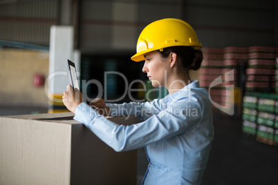 Female factory worker using digital tablet in factory