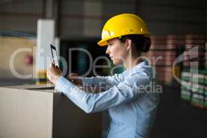 Female factory worker using digital tablet in factory