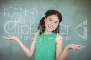 Portrait of schoolgirl gesturing while pretending to be a teacher in classroom