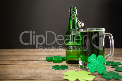 Mug of green beer, beer bottle and shamrocks for St Patricks Day