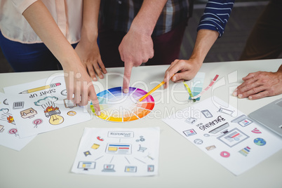 Mid section of graphic designers interacting with each other while working Mid section of graphic designers interacting with each other while working