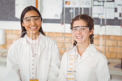 Portrait of smiling schoolgirls standing in laboratory