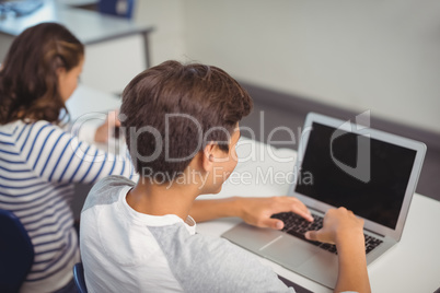 Student using laptop in classroom