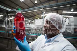 Factory engineer holding a bottle of juice