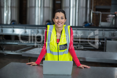 Portrait of factory worker standing in drinks production factory