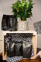 Coffee bags and pot plant on wooden table