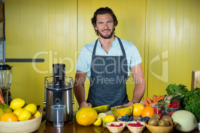 Portrait of smiling male staff standing at counter