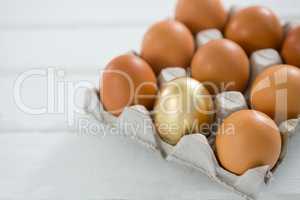 Golden Easter egg with brown eggs in tray