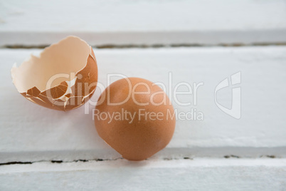 Broken brown Easter egg on wooden surface