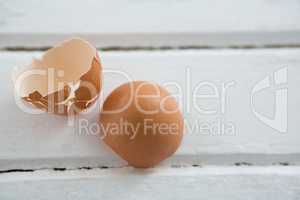 Broken brown Easter egg on wooden surface