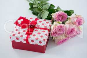 Gift box with bunch of rose on white background