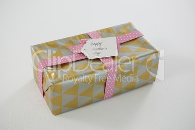 Gift box with happy mothers day tag on white background