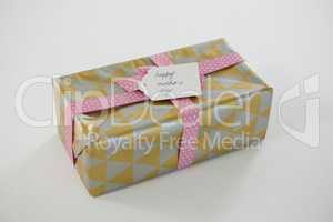Gift box with happy mothers day tag on white background