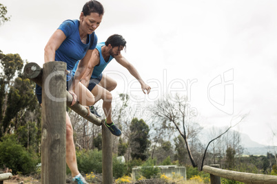 Couple jumping over the hurdles during obstacle course