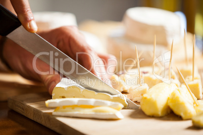 Staff cutting cheese at counter in market