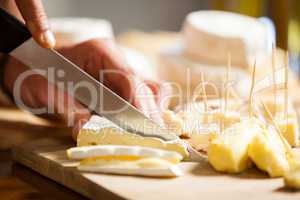 Staff cutting cheese at counter in market