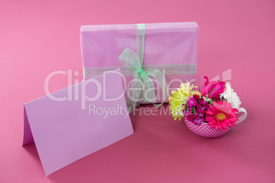 Gift box with happy mother day tag and blank card against pink background
