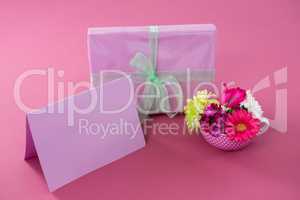 Gift box with happy mother day tag and blank card against pink background