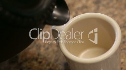 Slow Motion of Pouring Coffee Into Mug in Kitchen With Room For Text. Clip Continues as Bubbles Float and Pop