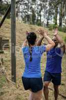 Couple giving high five to each other during obstacle course