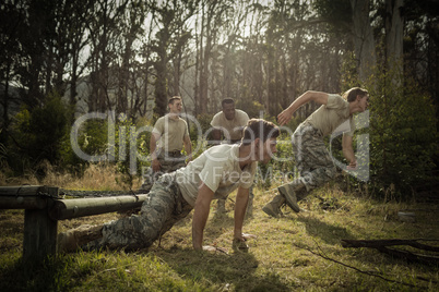 Soldiers crawling under the net during obstacle course