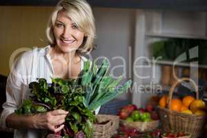 Portrait of female costumer holding fresh vegetables in organic section