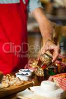 Staff checking pickle jar at counter in market
