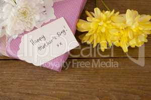 Happy mothers day card on gift box with flowers
