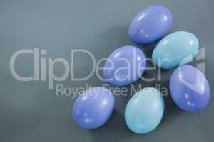 Violet and turquoise Easter eggs on grey background