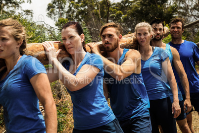 People carrying a heavy wooden log during boot camp