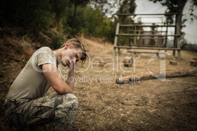 Tired soldier with hand on head sitting
