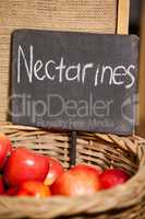 Close-up of fresh nectarines with placard in organic section