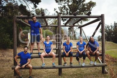 Fit people sitting on the obstacle couse in bootcamp