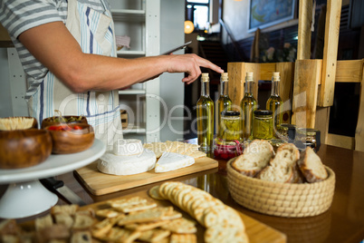 Staff counting olive oil bottle at counter