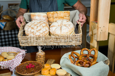 Male staff holding a basket of bread