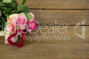 Bunch of pink roses on wooden plank