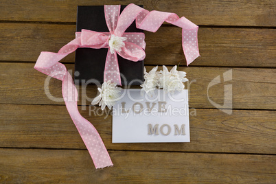 Gift box with love mom text on wooden plank