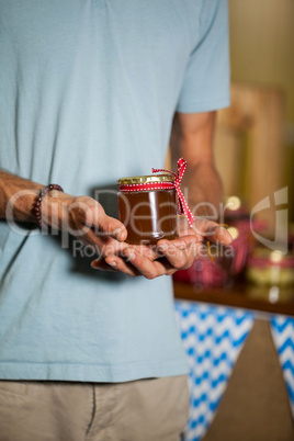 Mid-section of man holding a jar of jam