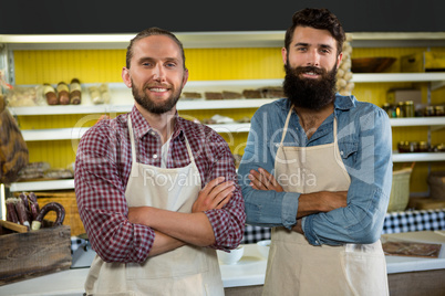 Portrait of smiling two male staff standing with arms crossed Portrait of smiling two male staff standing with arms crossed